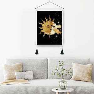 Bohemian sun and moon tapestry with black tassels hanging over a modern living room sofa