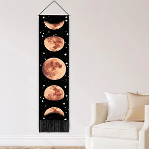 Vertical lunar phase tapestry with gold moon graphics and black tassels on white wall