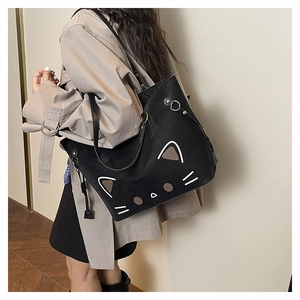 Close-up of black tote bag featuring a minimalist cat face print on premium matte leather