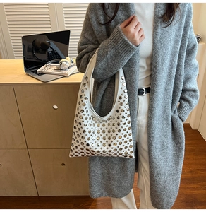 Sac seau blanc avec rivets et œillets métalliques argentés dans un cadre de bureau