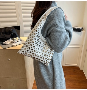 Détail du sac seau blanc à bandoulière avec rivets métalliques argentés et style moderne