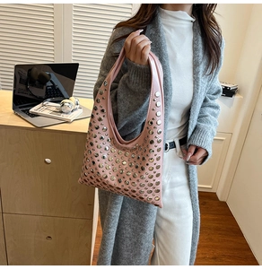 Sac hobo rose orné de clous argentés avec bandoulière dans un décor de style de vie
