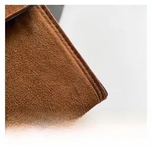 Close-up of caramel brown suede handbag showing fine texture and neat stitching