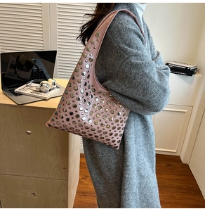 Pink rivet bucket bag detail showing silver studs and premium leather texture in casual setting