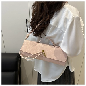 Détail du sac à main rose pâle avec gaufrage crocodile et fermoir métallique doré