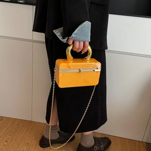 Yellow marble acrylic clutch bag with gold U-shaped handle and crossbody chain