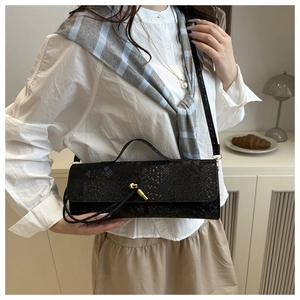 Détails de la texture crocodile et fermoir doré sur le sac baguette noir élégant