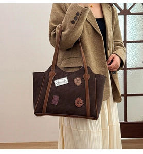 Detail of vintage badge embroidery and retro puppy patch on brown tote bag surface