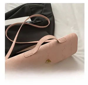 Détail du sac à main rose motif serpent avec fermoir doré et poignée élégante