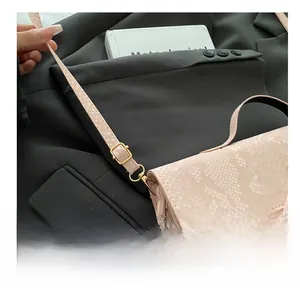 Détail du sac à bandoulière rose en similicuir serpent avec boucle en métal doré
