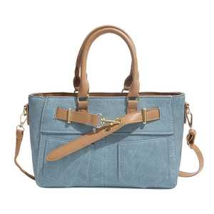 Blue denim patchwork tote bag with brown leather handles and gold metal clasp