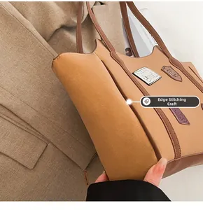 Detail of vintage badge and puppy embroidery on khaki tote bag with contrast piping