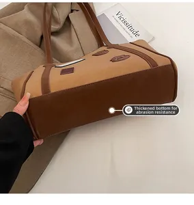 Detail of thickened wear-resistant bottom and retro badge on brown leather tote bag