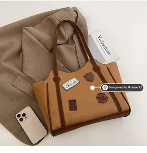 Detail of vintage brown tote bag with retro patches and adjustable shoulder strap