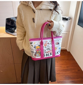 Detail of canvas graffiti tote bag with pink leather trim in a lifestyle office setting