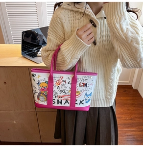 Detail of white canvas tote bag with colorful graffiti art and magenta leather trim