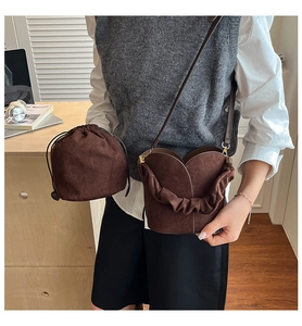 Detail of dark brown matte bucket bag showing the ruched handle and drawstring pouch