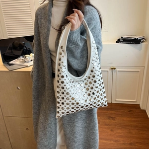 Sac seau blanc avec rivets argentés style Y2K porté par un mannequin féminin
