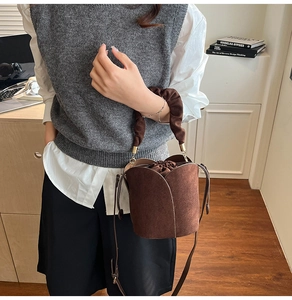 Detail of dark brown petal bucket bag with pleated handle and drawstring inner pouch