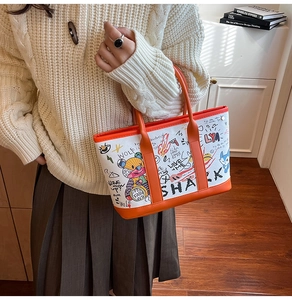 Detail of graffiti tote bag showing colorful hand-painted art and orange PU trim accents
