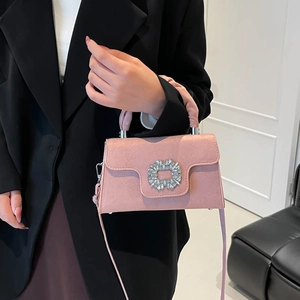 Pink pleated square bag with rhinestone buckle shown on model with shoulder strap