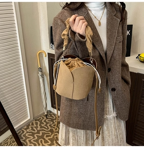 Detail of camel matte suede bucket bag featuring petal design and drawstring closure