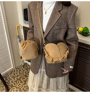 Detail of khaki suede bucket bag and heart-shaped crossbody bag with soft matte texture
