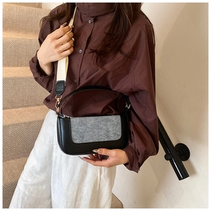 Close-up of contrast patchwork handbag with wool flap and wide fabric shoulder strap