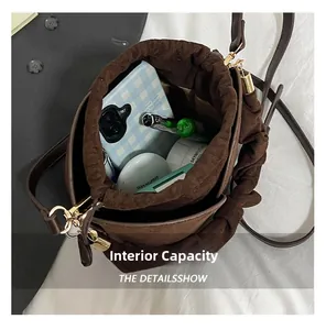 Detail showing the internal capacity of the brown suede bucket bag with daily essentials