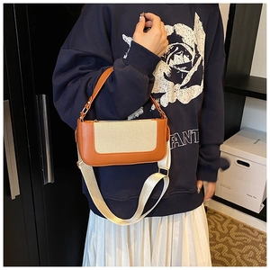 Detail of contrasting leather and canvas crossbody bag with orange and beige textures