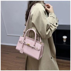 Vue détaillée du sac à main en cuir rose avec fermoir doré sur un trench-coat kaki
