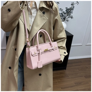 Vue détaillée du sac à main en cuir rose avec fermoir doré et bandoulière réglable
