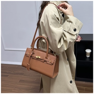 Sac à main en cuir marron grainé porté par un mannequin avec une bandoulière