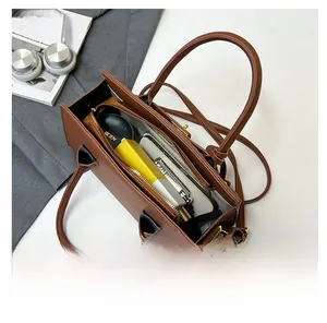 Détail intérieur d'un sac cabas en cuir grainé marron avec compartiment zippé central