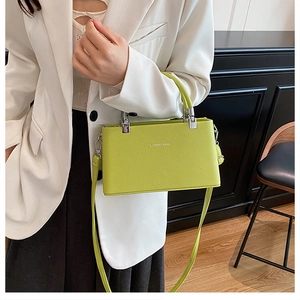 Detailed macro view of the lemon green lychee leather texture and silver buckle on bag