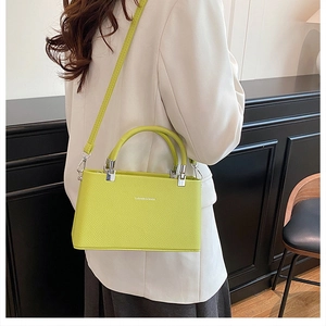 Detail of lime green pebble leather handbag featuring silver hardware and crossbody strap