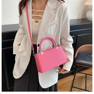 Close-up of bright pink leather texture and silver hardware on a mini box handbag