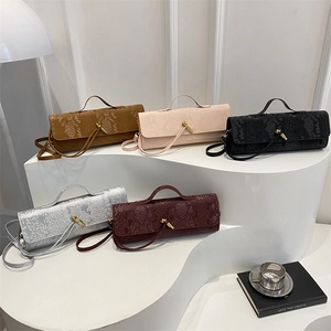 Sacs à main embossés crocodile multicolores exposés sur un support blanc minimaliste