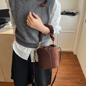 Brown frosted petal bucket bag with drawstring closure and ruched handle shown on model