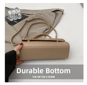 Close-up of the wear-resistant wide base and fine leather texture on the khaki handbag