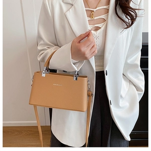 Detail of caramel lychee grain leather handbag with silver hardware and shoulder strap