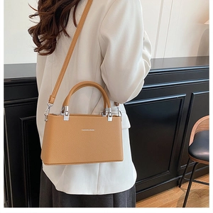 Close-up of mustard yellow litchi grain leather bag with silver metal hardware detail