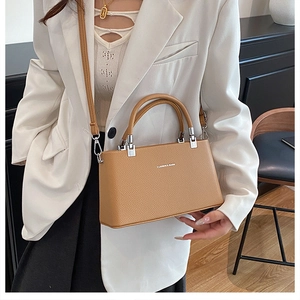 Detail of camel leather handbag with litchi grain texture and adjustable shoulder strap