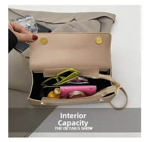 Interior view showing the storage capacity of a beige crossbody bag with gold hardware