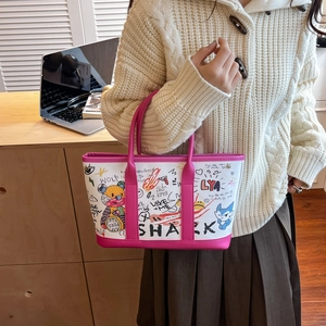 Graffiti bear bucket bag with pink handles and shark prints on white background