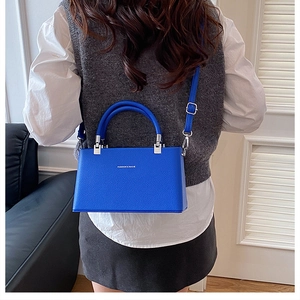 Detailed view of the electric blue lychee pattern leather on a crossbody box bag