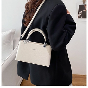 Close-up of cream textured leather handbag with silver hardware and fashion lettering