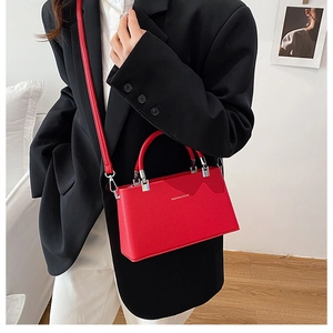Detail of red lychee leather texture and silver hardware on a mini fashion handbag