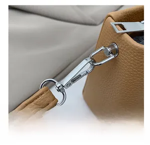Detail of silver metal hook and textured lychee grain leather on tan handbag
