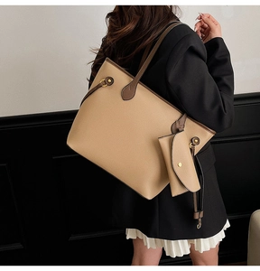 Détail d'un sac cabas en cuir grainé kaki avec bandoulière marron et petite pochette